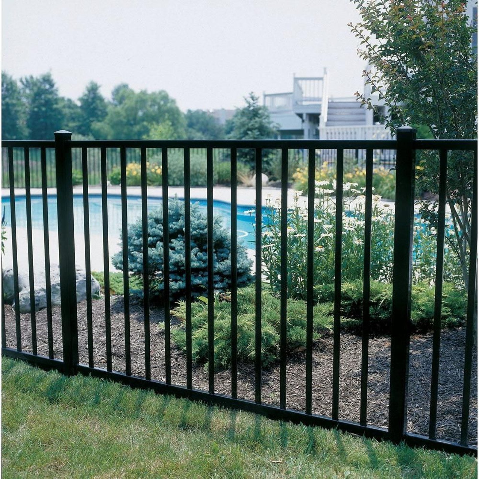 Aluminum fence panel and post detail in a landscaped yard